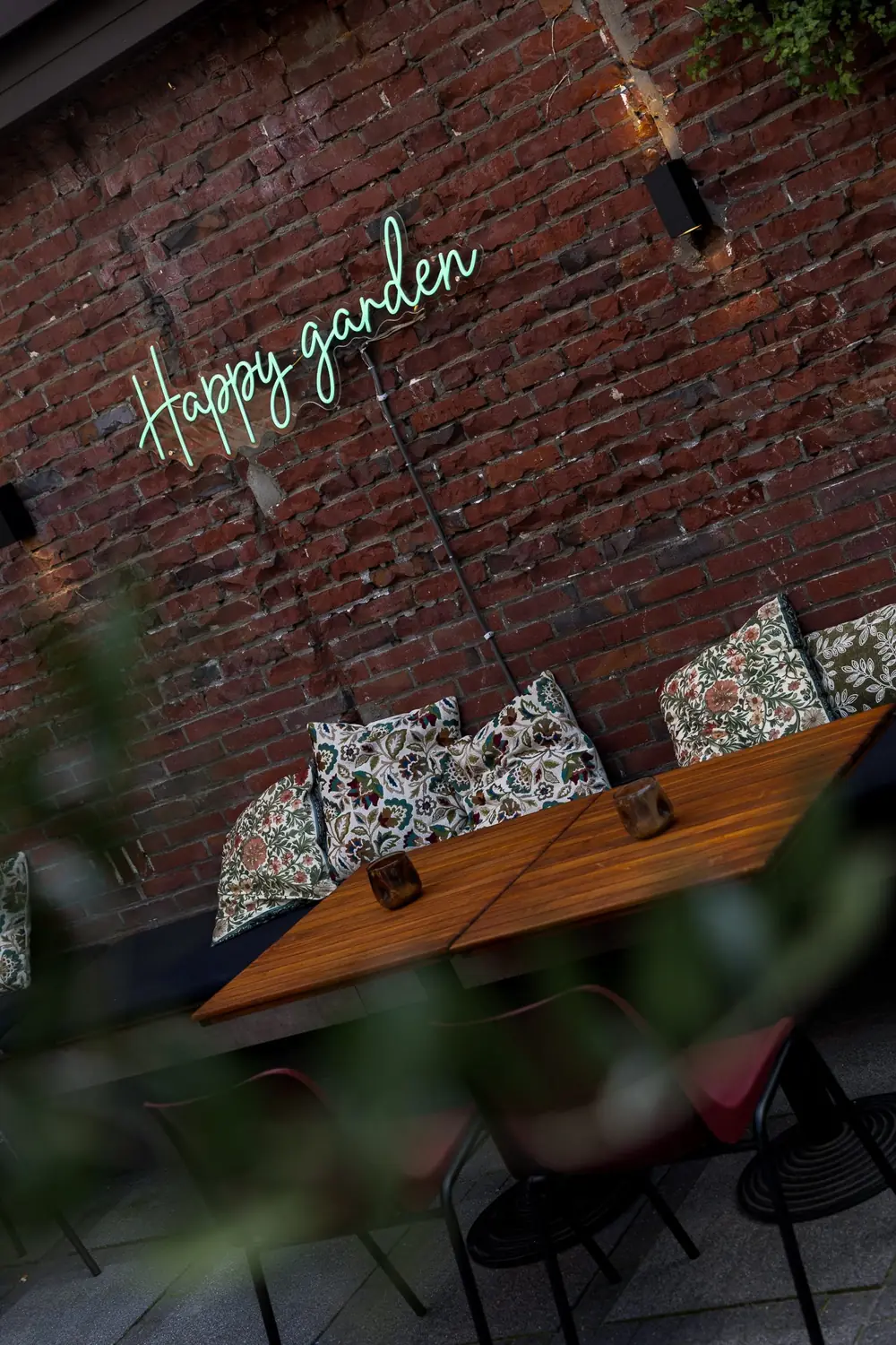 Neon Happy garden op de bakstenen muur van de overdekte binnentuin