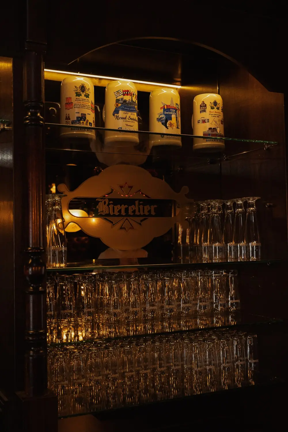 De achterbar met het verlichte Bierelier-bord en de jubileumpullen